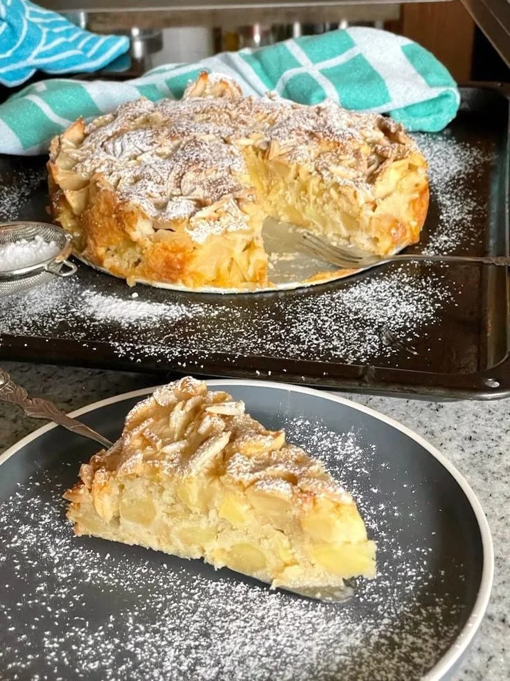 Einfacher mega saftiger Apfelkuchen auf einem Teller mit frischen Äpfeln