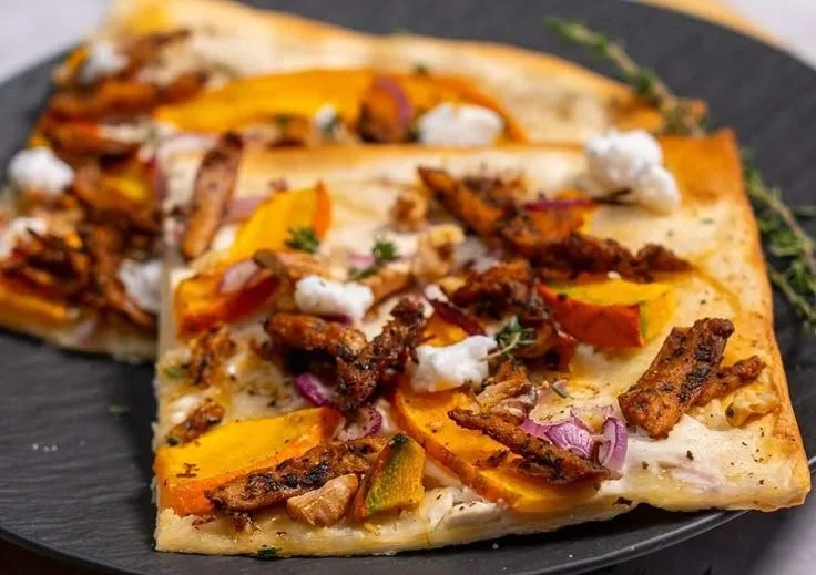Kürbis Flammkuchen mit frischen Zutaten und herbstlicher Dekoration