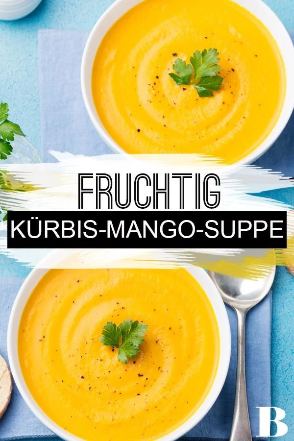 Schüssel mit Kürbis-Mango-Suppe, dekoriert mit frischen Kräutern.