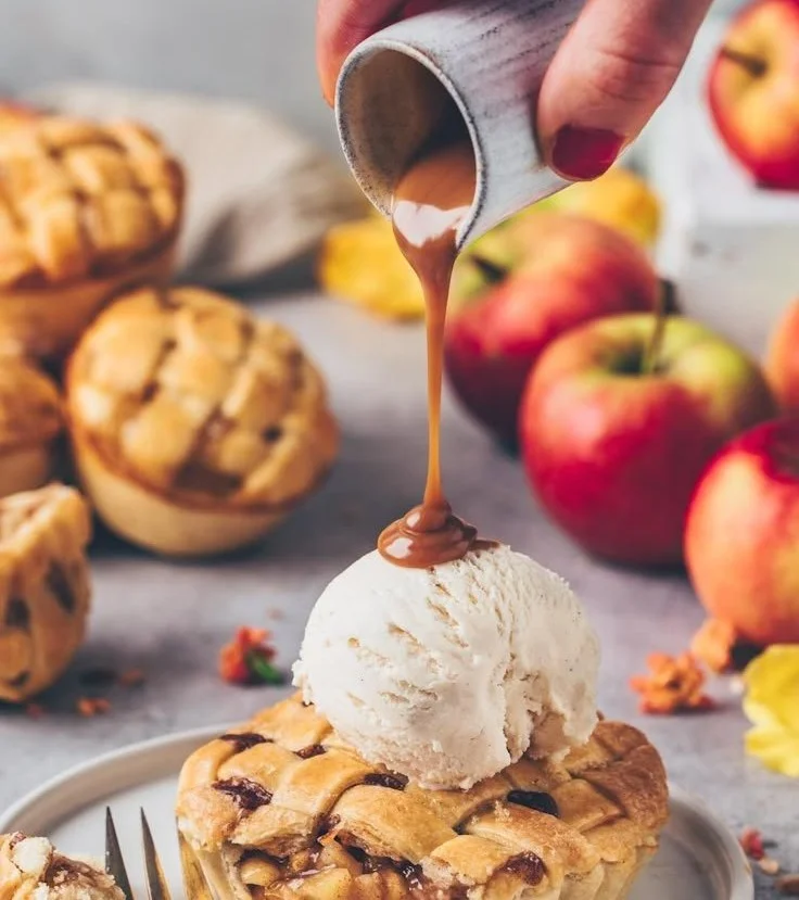 Vegane Mini Apfel-Pies auf einem rustikalen Holzbrett serviert.