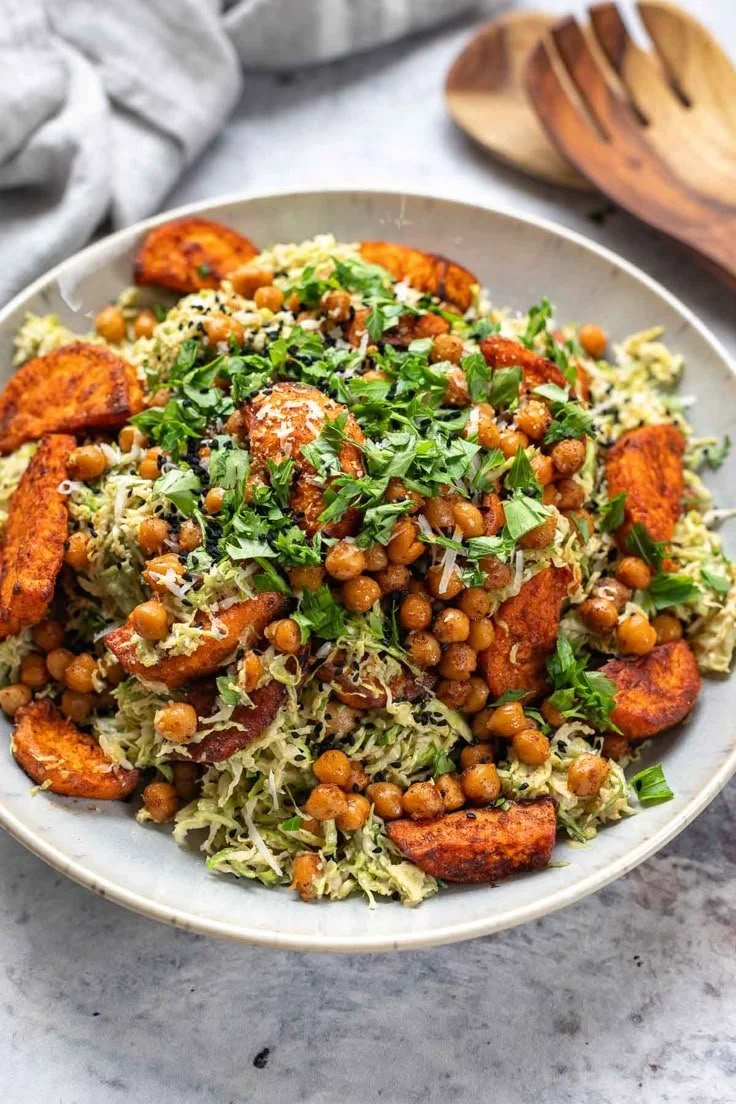 Rosenkohl Salat mit Süßkartoffeln und Kichererbsen auf einem Teller